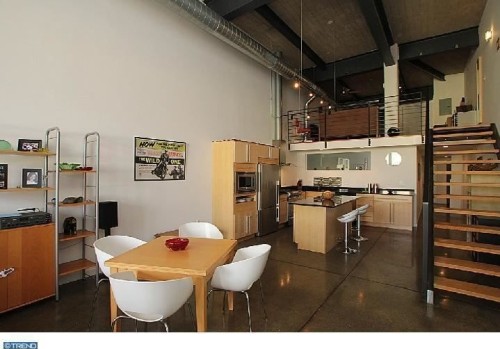The industrial condo features 15-foot ceilings, exposed brick, steel beams and polished concrete floors.